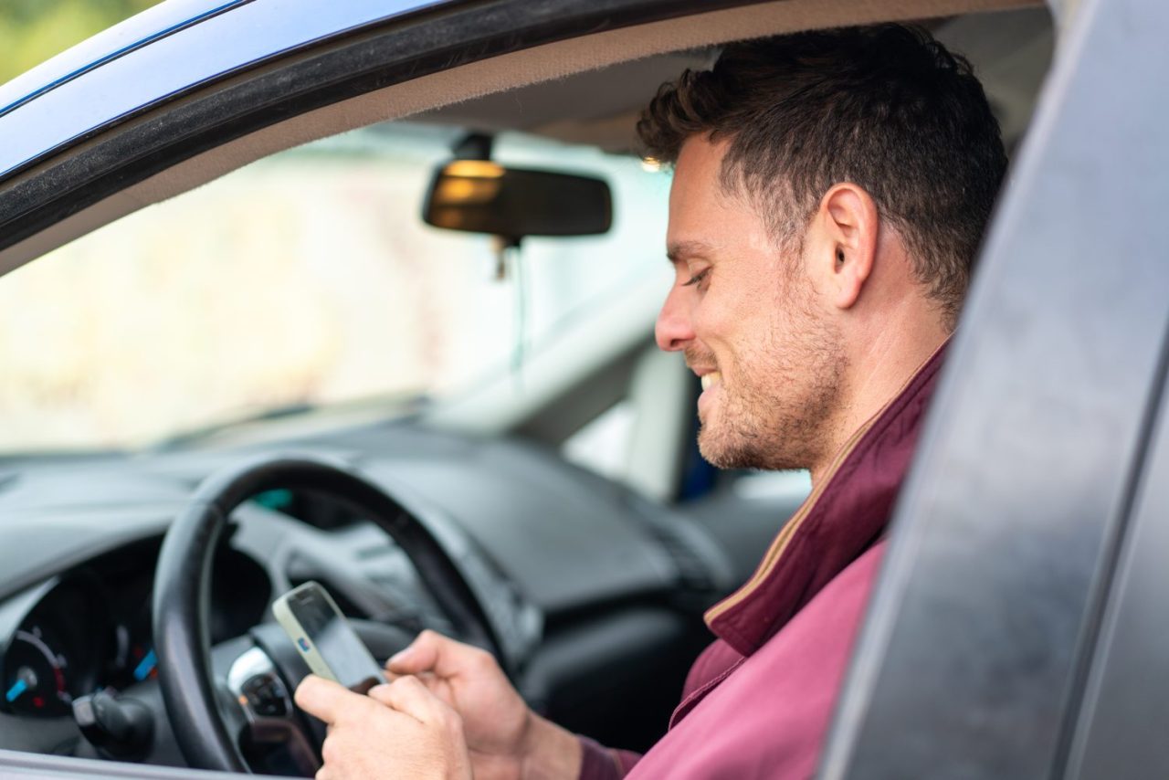 Conducteur vérifiant l’alarme de sa voiture stationnée.